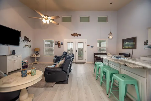 a living room with furniture a flat screen tv and kitchen view