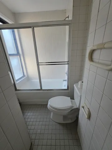 a white toilet sitting next to a bath tub