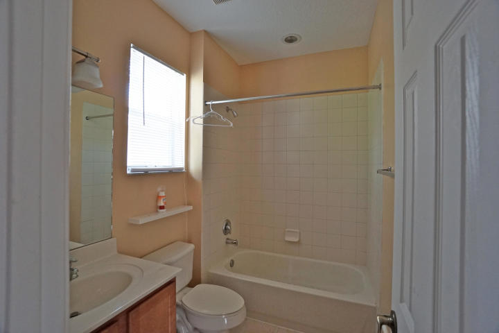 3259 Laurel Ridge Circle Riviera Beach, FL 33404 - Photo 4 of 6 a bathroom with a granite countertop bathtub shower sink vanity and toilet