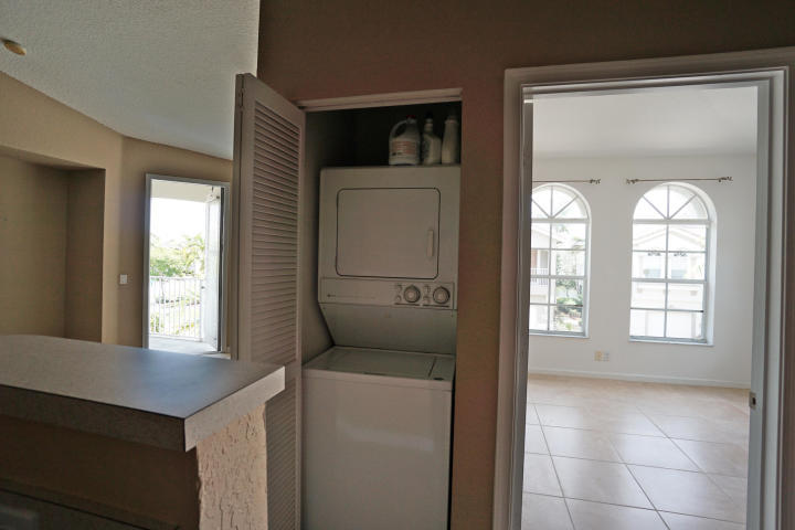 3259 Laurel Ridge Circle Riviera Beach, FL 33404 - Photo 5 of 6 a hallway with windows and brick walls
