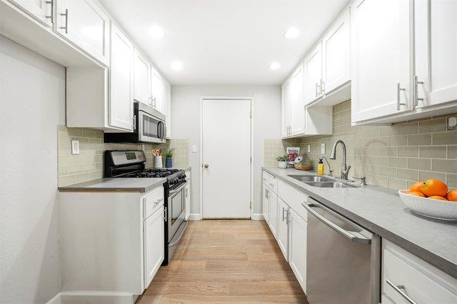 8550 Wren Avenue, Unit 3B Gilroy, CA 95020 - Photo 6 of 27 a kitchen with stainless steel appliances a sink a stove top oven a counter space and cabinets