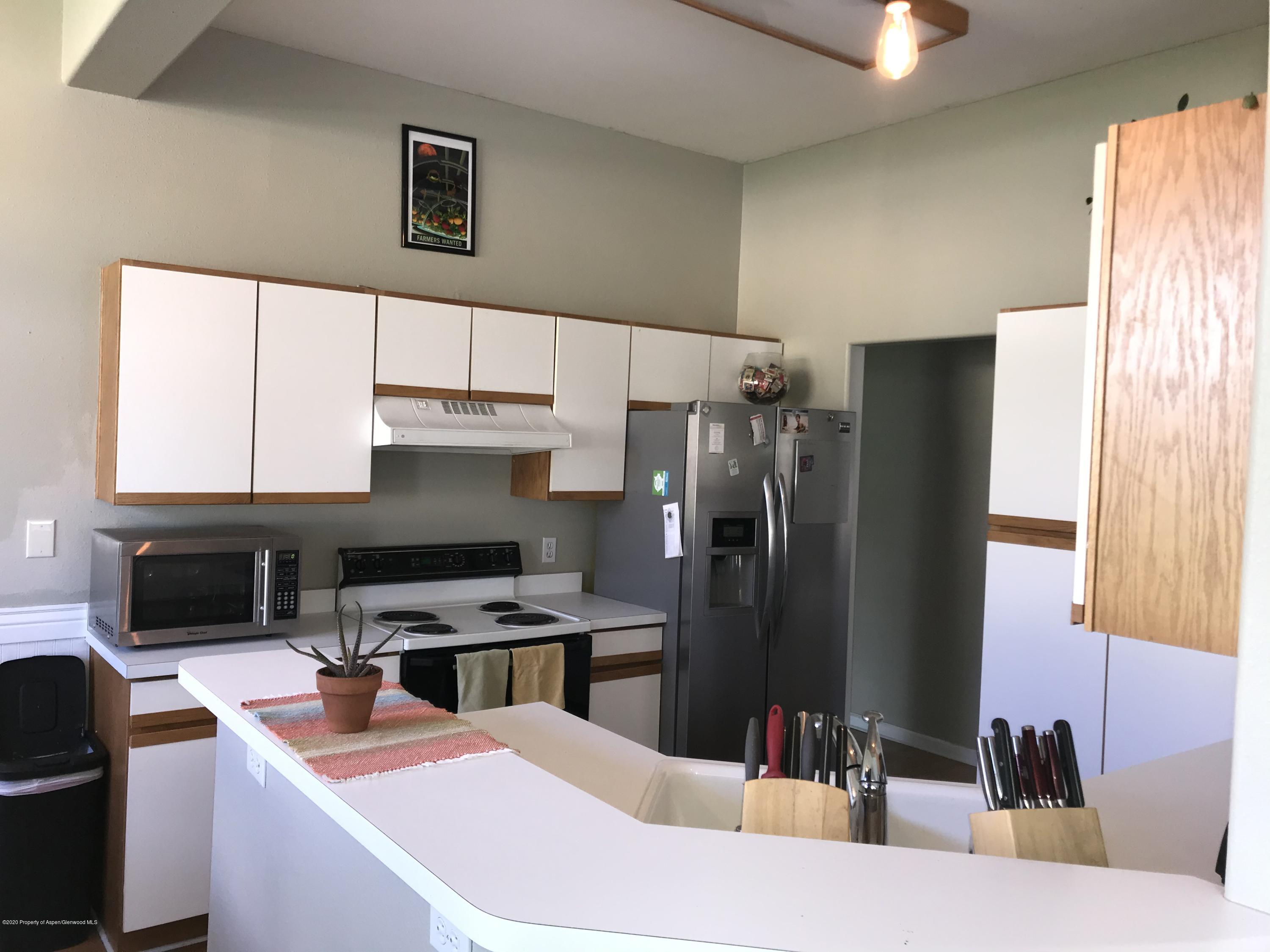 16 Limberpine Circle Parachute, CO 81635 - Photo 8 of 22 a kitchen with stainless steel appliances kitchen island granite countertop a refrigerator and a stove top oven