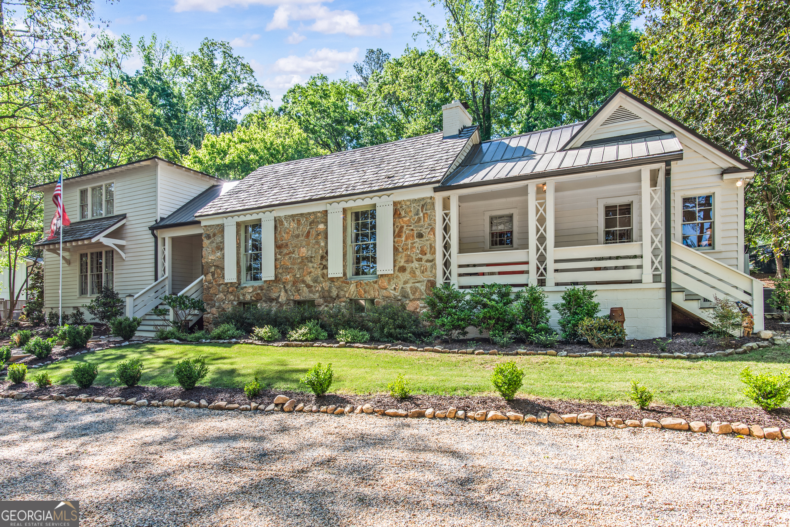 a front view of a house with a yard and potted plants