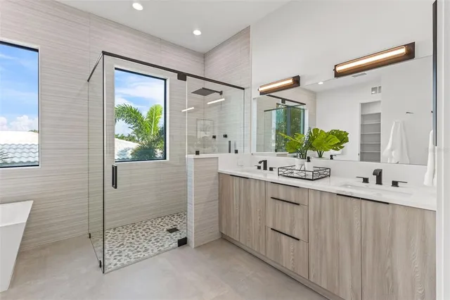 a spacious bathroom with a double vanity sink mirror and bathtub
