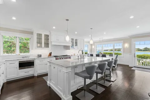 a kitchen with a stove a sink a kitchen island with a dining table and chairs