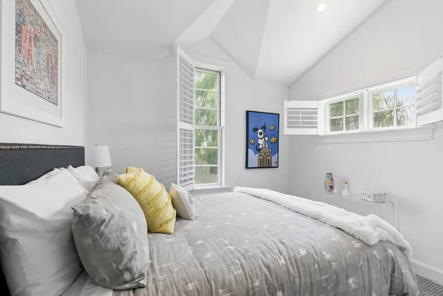 a bed sitting in a bedroom next to a window