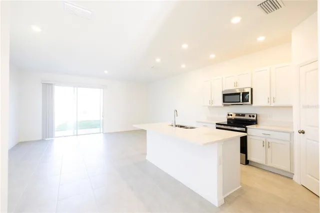 a kitchen with stainless steel appliances a refrigerator stove microwave and sink