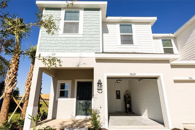 a view of a house with a small yard and potted plants