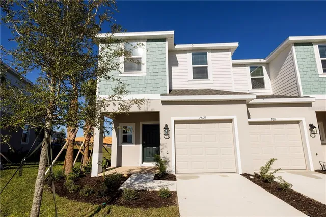 a view of a hallway with wooden floor and a bathroom
