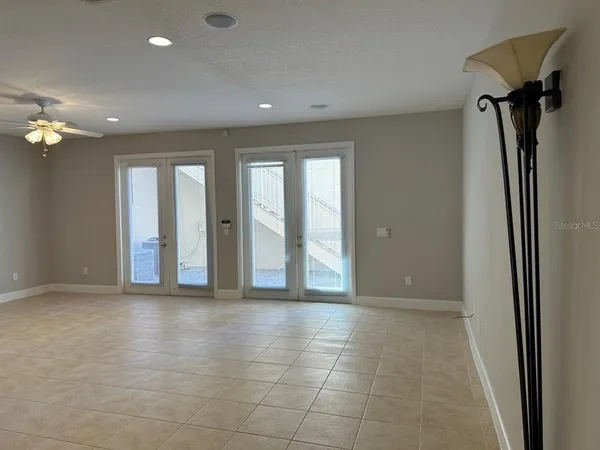 a view of an empty room with glass door and a chandelier