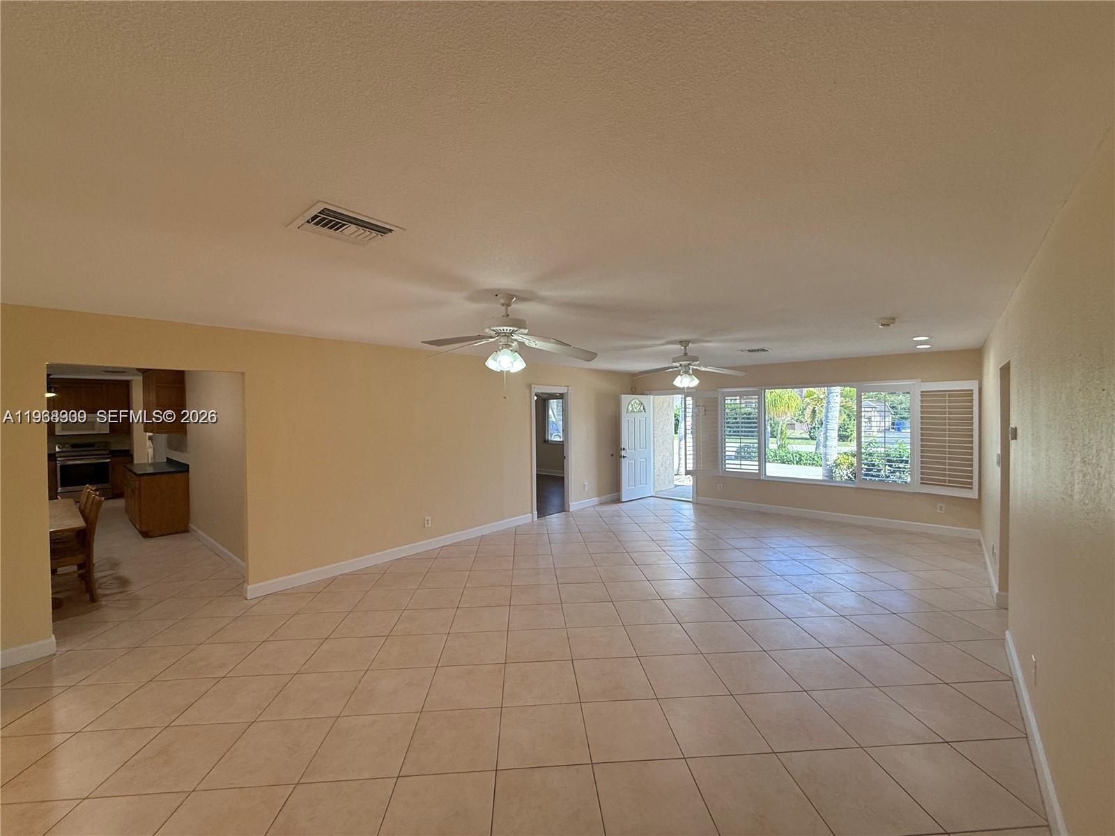2271 Southwest 30th Terrace Fort Lauderdale, FL 33312 - Photo 5 of 40 an empty room with windows and ceiling fan