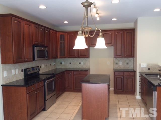 136 Locke Woods Road Raleigh, NC 27603 - Photo 5 of 18 a kitchen with kitchen island granite countertop wooden cabinets stainless steel appliances a sink and a counter top space