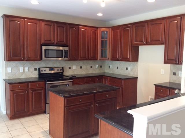 136 Locke Woods Road Raleigh, NC 27603 - Photo 7 of 18 a kitchen with granite countertop wooden cabinets and stainless steel appliances