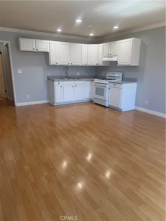a large kitchen with stainless steel appliances cabinets a sink and a stove