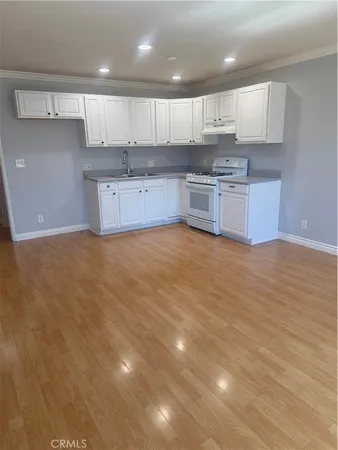 a kitchen with granite countertop a stove top oven sink and cabinets
