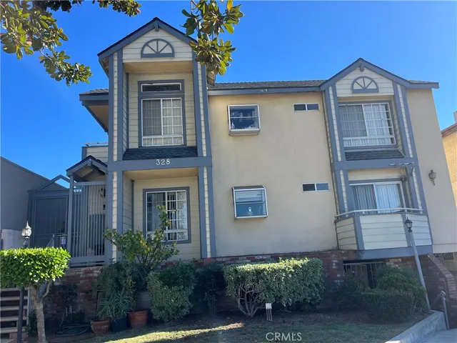 a view of a house with a small yard and potted plants