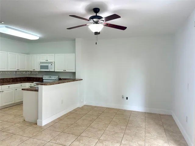 a kitchen with a stove cabinets and white appliances
