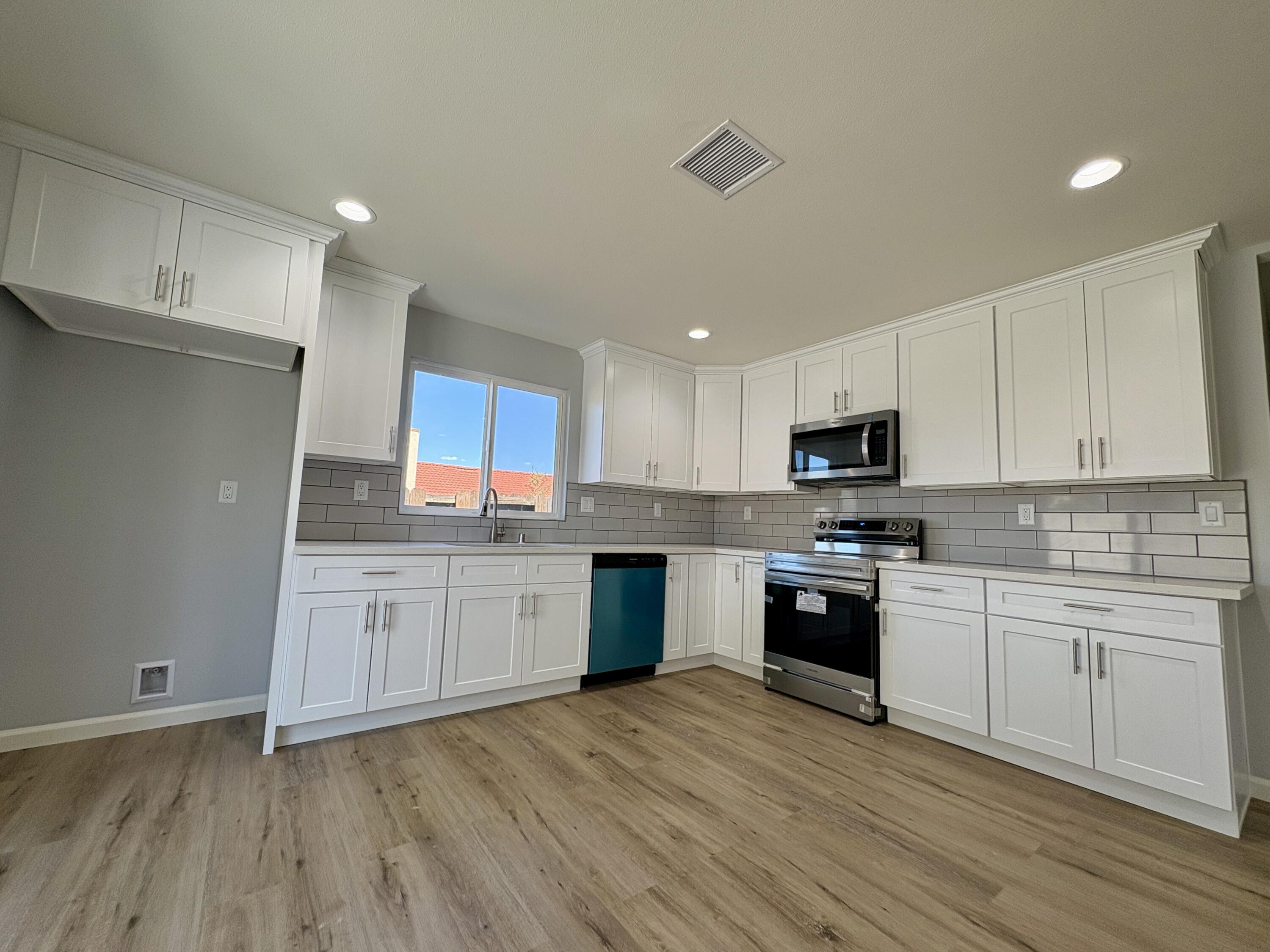 37132 Kendrick Circle, Unit B Palmdale, CA 93550 - Photo 2 of 10 a kitchen with granite countertop a sink cabinets and wooden floor