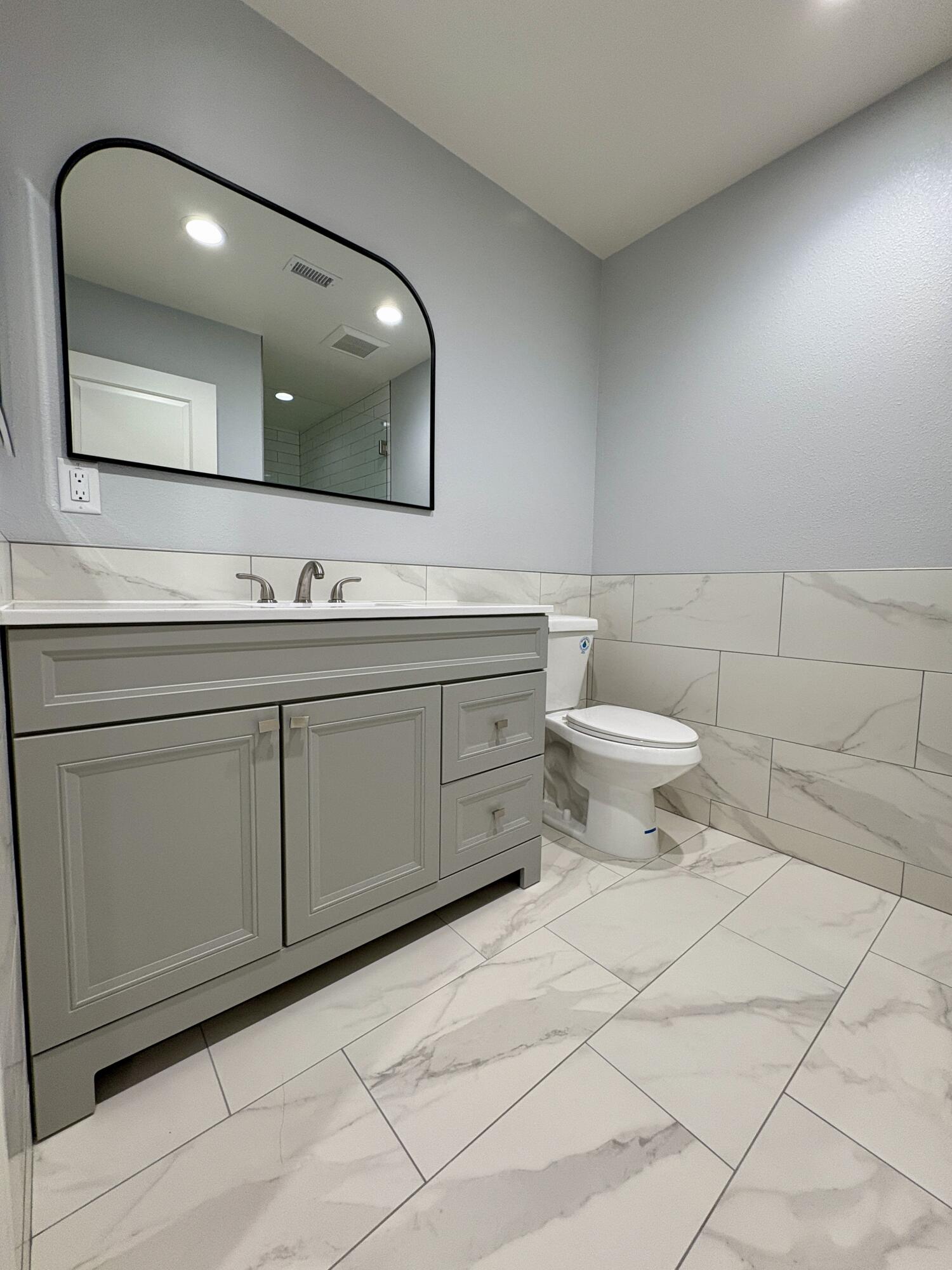 37132 Kendrick Circle, Unit B Palmdale, CA 93550 - Photo 5 of 10 a bathroom with a toilet sink and mirror