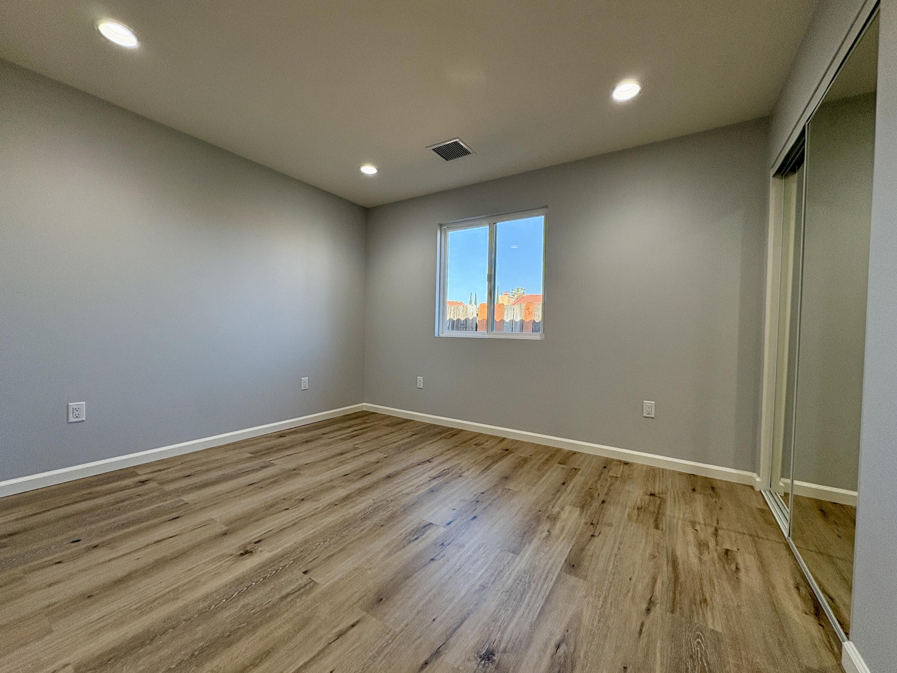 37132 Kendrick Circle, Unit B Palmdale, CA 93550 - Photo 7 of 10 an empty room with wooden floor and windows