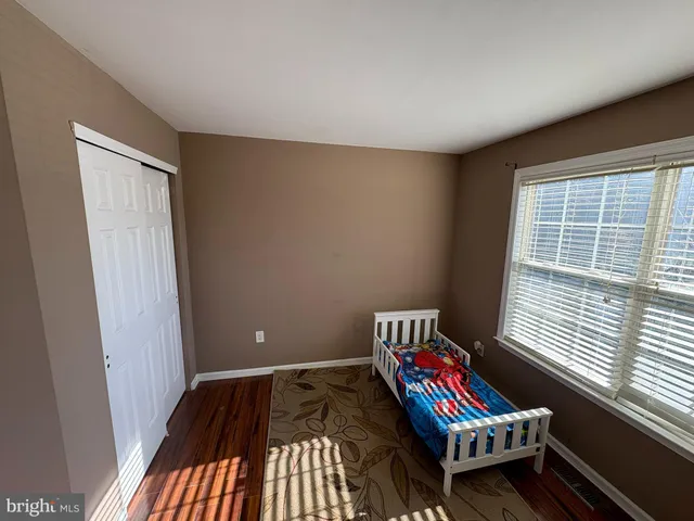 a living room with a baby crib furniture and a window