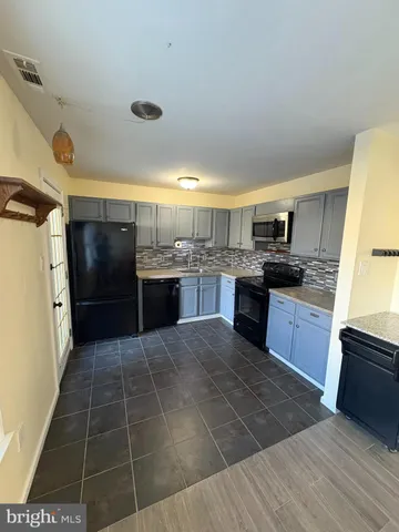 a large kitchen with stainless steel appliances granite countertop a stove a sink and a refrigerator