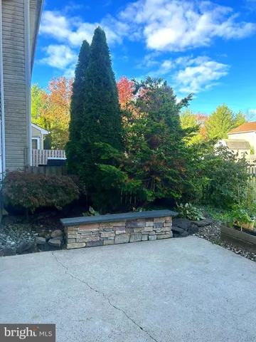 a view of wooden house with a yard and large trees