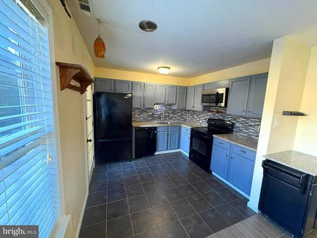 a kitchen with stainless steel appliances granite countertop a refrigerator stove and sink