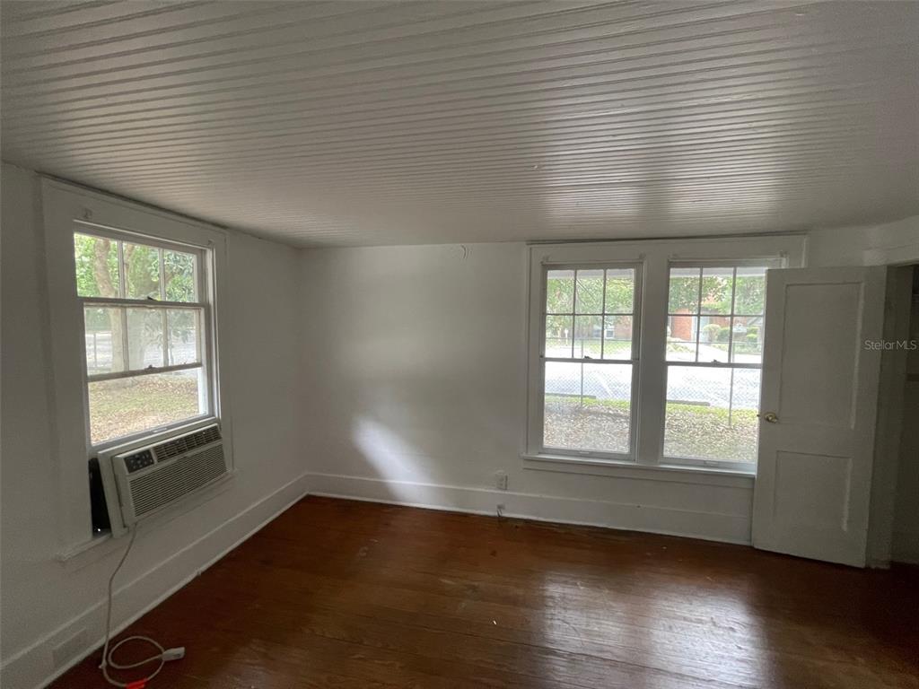 2635 West University Avenue Gainesville, FL 32607 - Photo 11 of 15 an empty room with wooden floor and windows