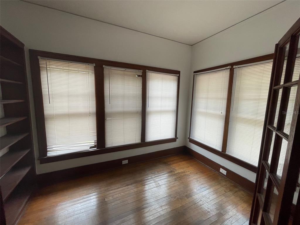 2635 West University Avenue Gainesville, FL 32607 - Photo 3 of 15 an empty room with wooden floor and windows