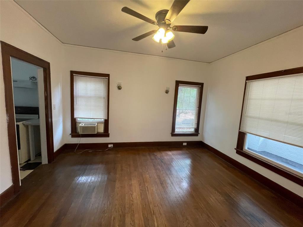 2635 West University Avenue Gainesville, FL 32607 - Photo 5 of 15 a view of an empty room with wooden floor and a window