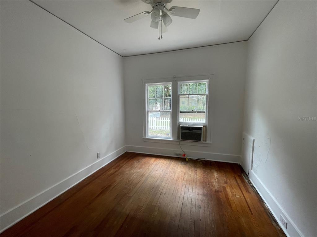 2635 West University Avenue Gainesville, FL 32607 - Photo 8 of 15 an empty room with wooden floor chandelier and windows