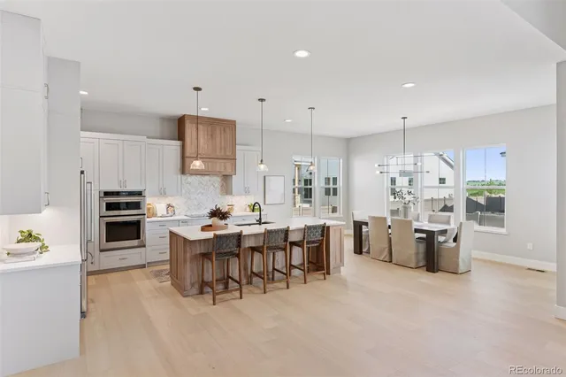 a kitchen with granite countertop a sink chairs and cabinets