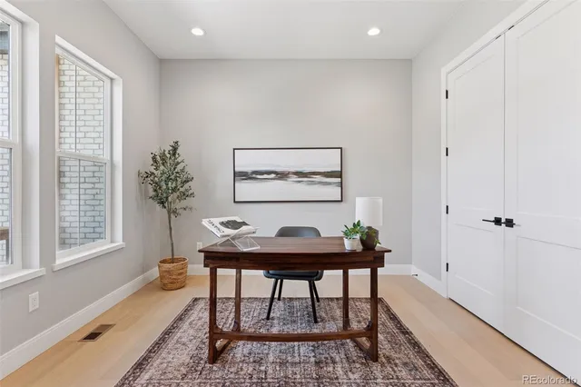 a view of a workspace with furniture and a window