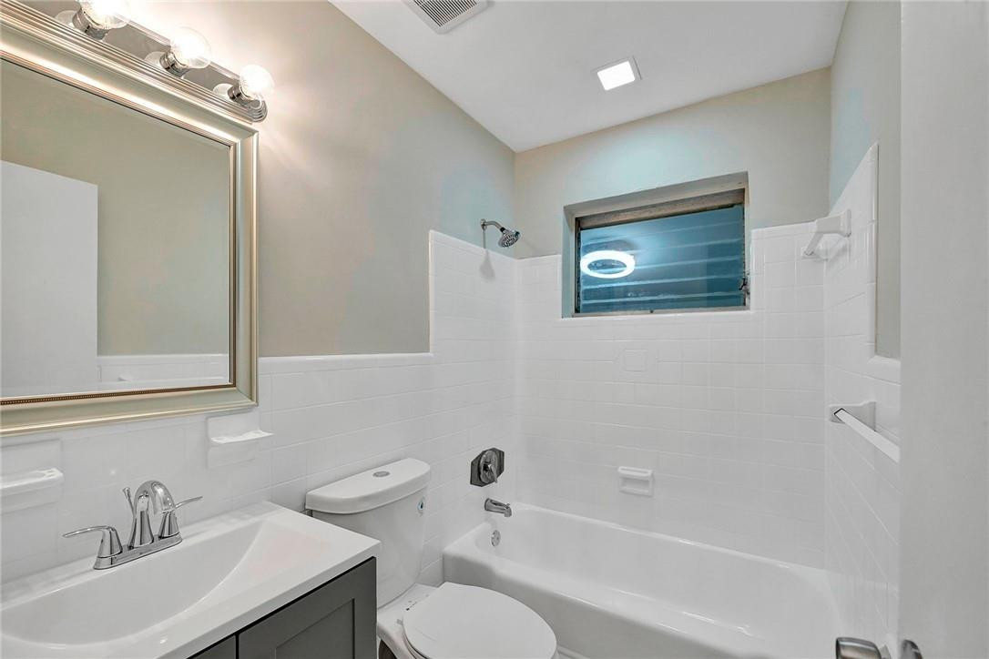 313 Southwest 9th Terrace Hallandale Beach, FL 33009 - Photo 16 of 20 a bathroom with a toilet a sink a mirror and shower