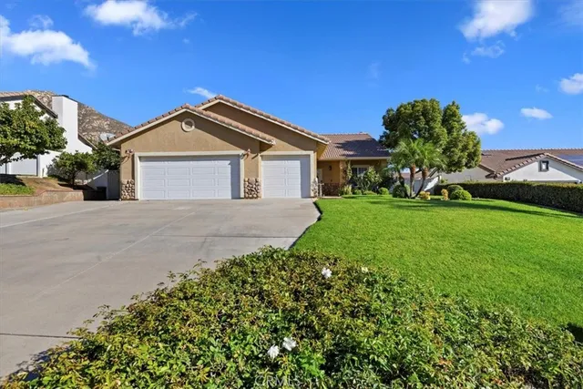 a view of a house with a big yard plants and large trees