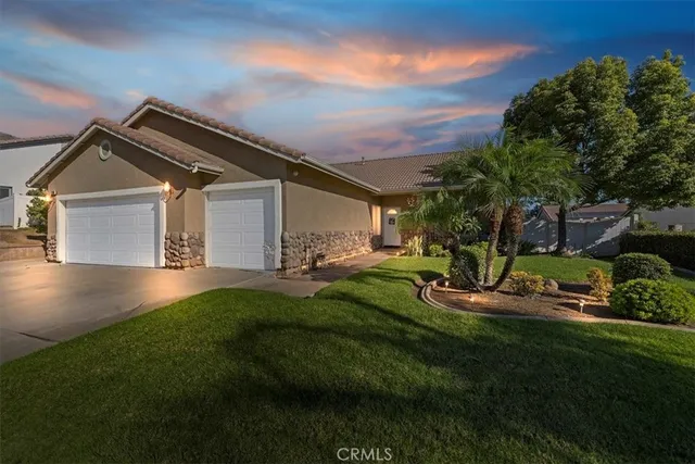 a front view of a house with a garden and yard