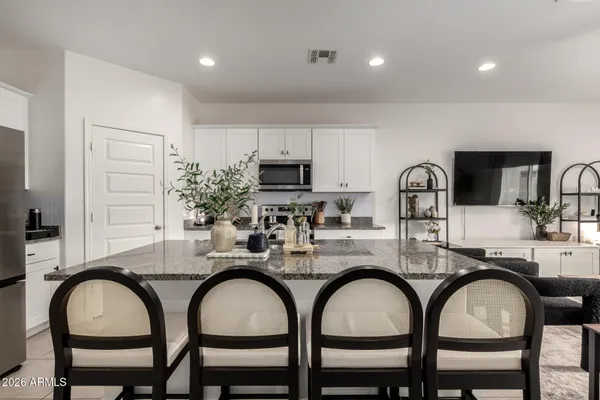 a kitchen with stainless steel appliances granite countertop a refrigerator and a stove top oven