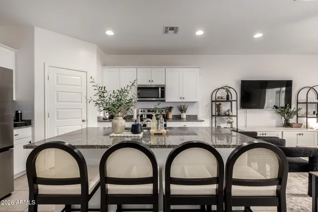 a kitchen with stainless steel appliances granite countertop a refrigerator and a stove top oven
