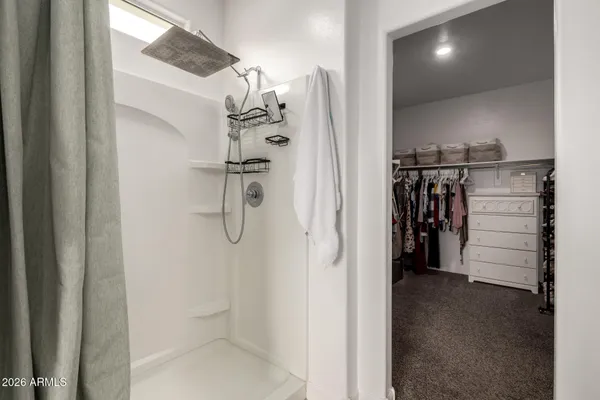 a view of walk in closet with clothes