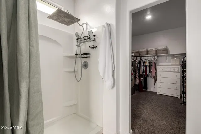 a view of walk in closet with clothes