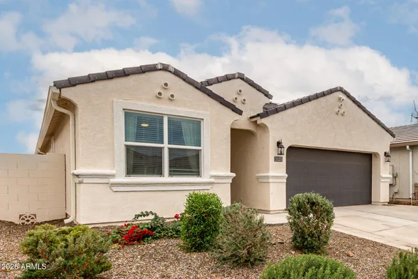 a view of a white house with a yard and potted plants