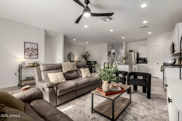 a living room with furniture a flat screen tv and kitchen view