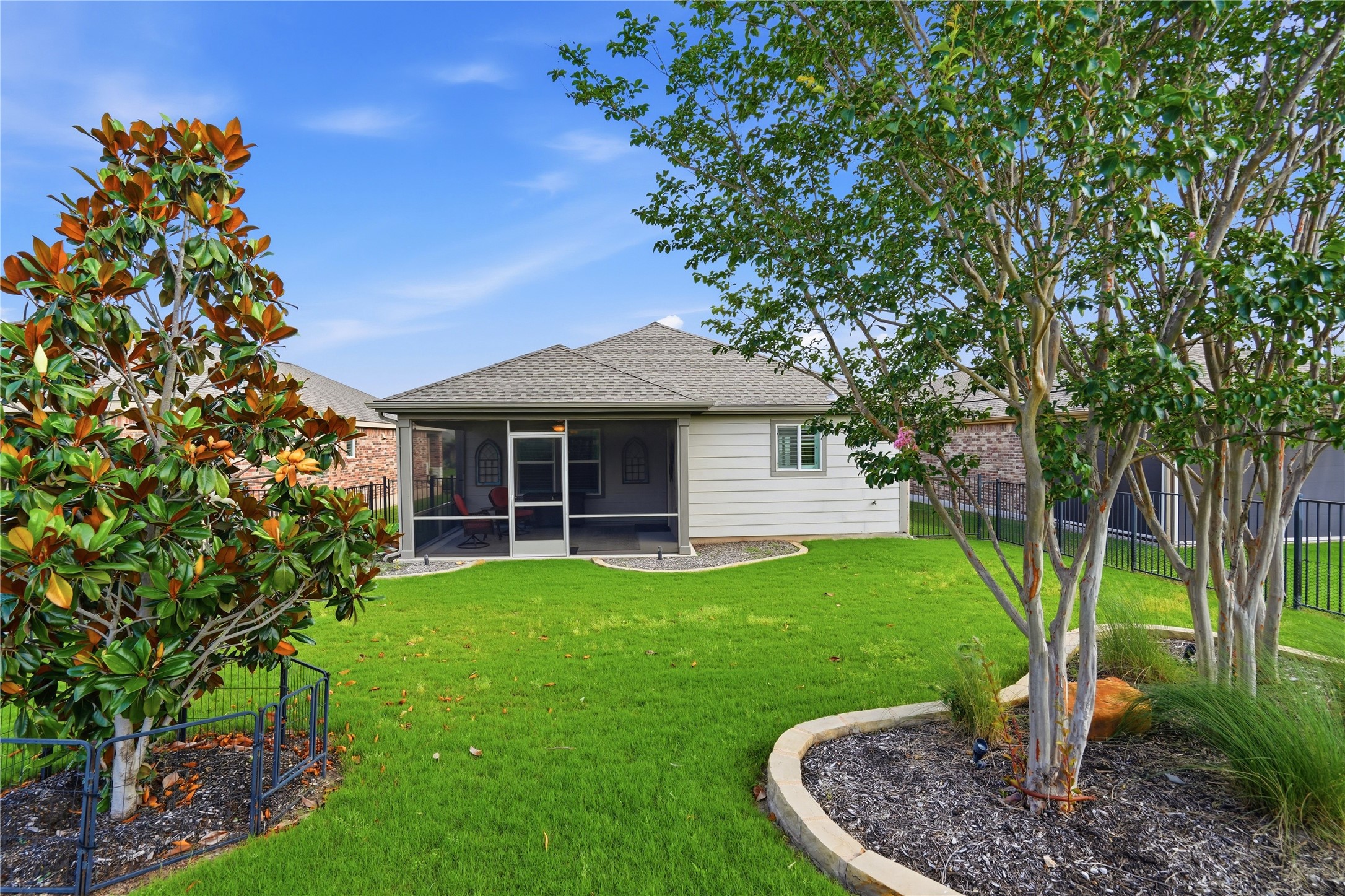 821 Hamilton Lane Georgetown, TX 78633 - Photo 23 of 38 Expansive backyard featuring a manicured lawn, screened-in patio, and mature trees