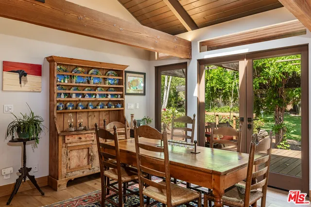 a dining room with stainless steel appliances kitchen island granite countertop furniture and a refrigerator