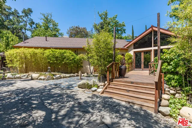 a view of a house with backyard and sitting area