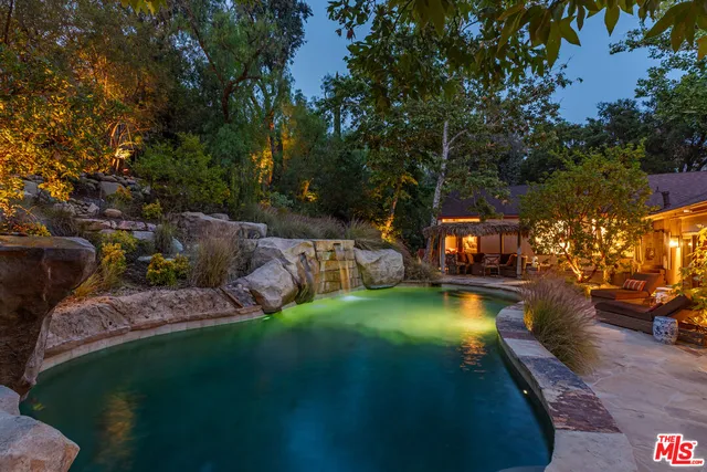 a view of a house with swimming pool and sitting area