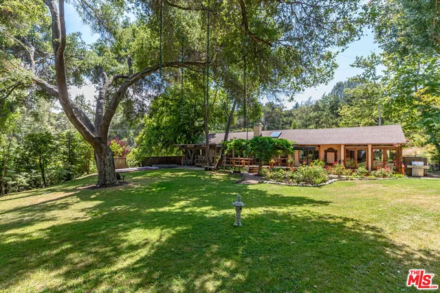 a view of a yard of a house with a tree