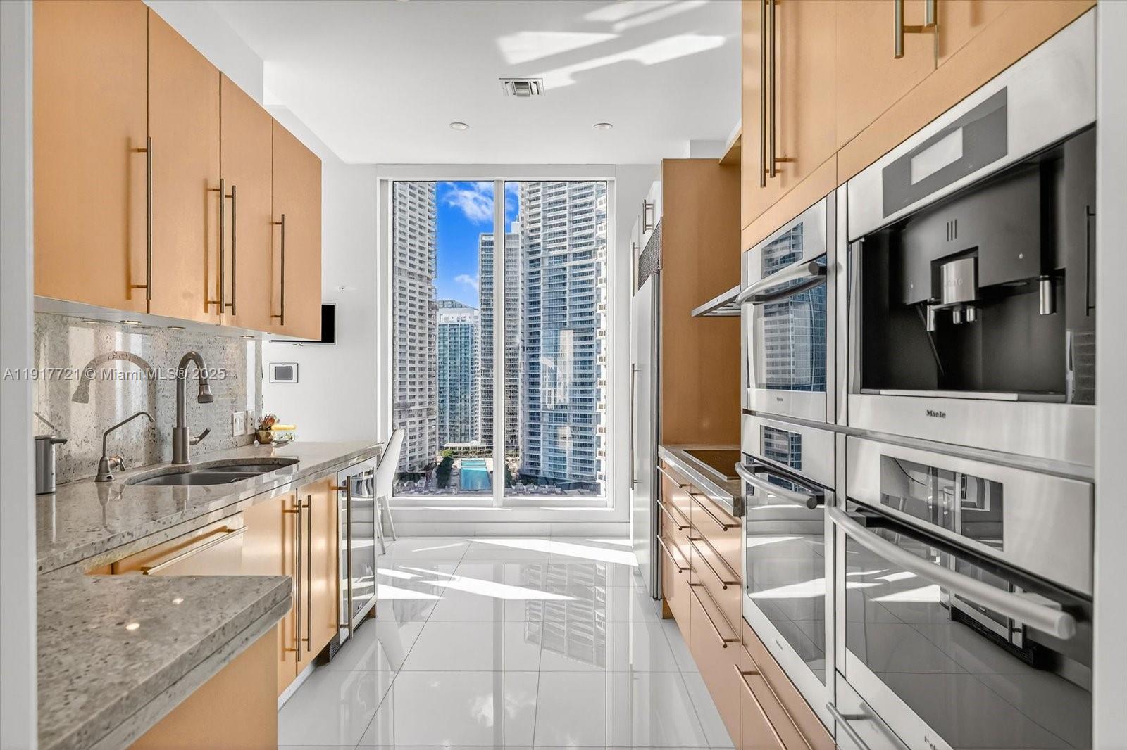 900 Brickell Key Boulevard, Unit 2304 Miami, FL 33131 - Photo 16 of 55 a kitchen with stainless steel appliances granite countertop a sink and a stove