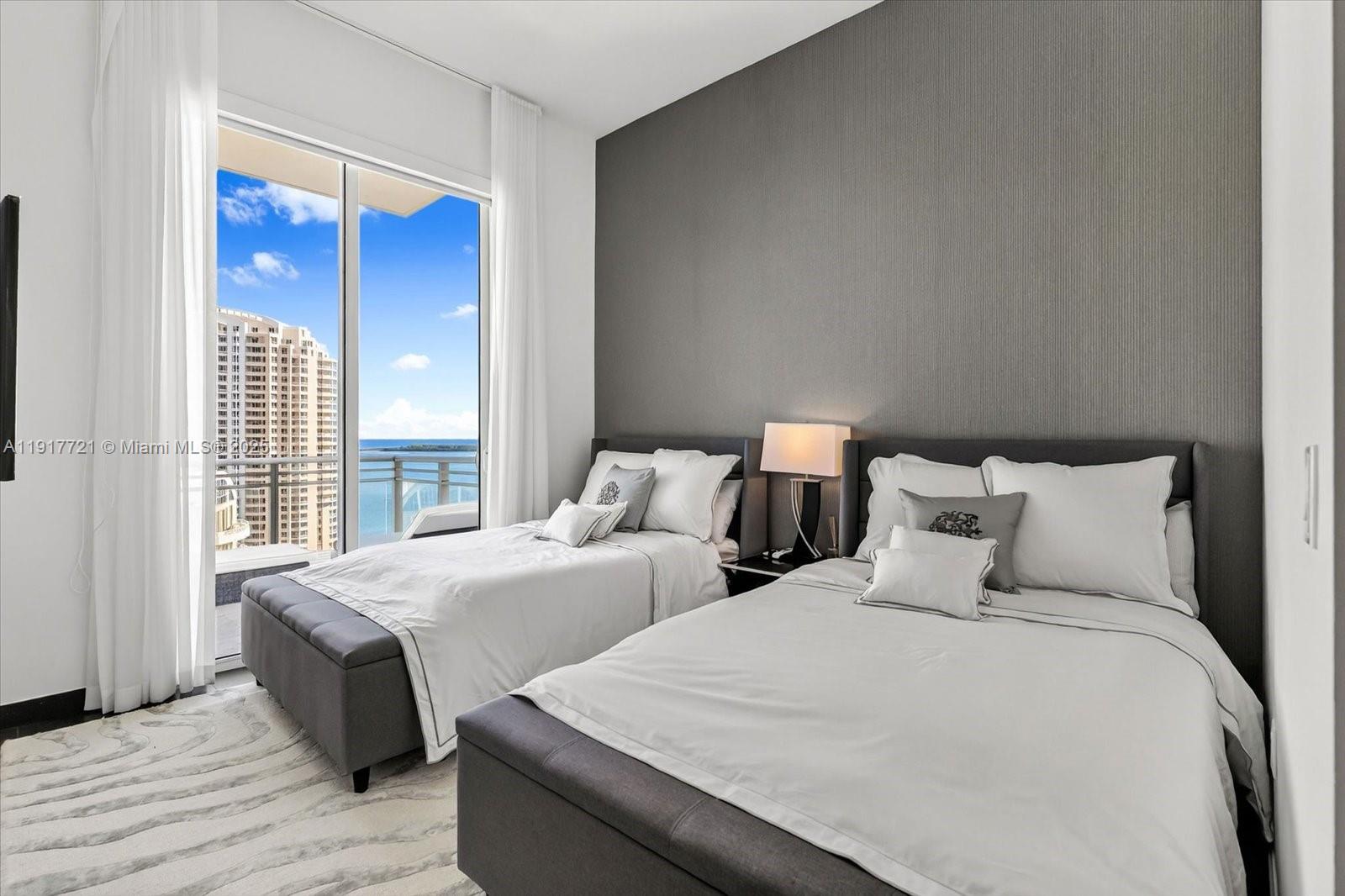 900 Brickell Key Boulevard, Unit 2304 Miami, FL 33131 - Photo 19 of 55 a bedroom with two beds and a large window